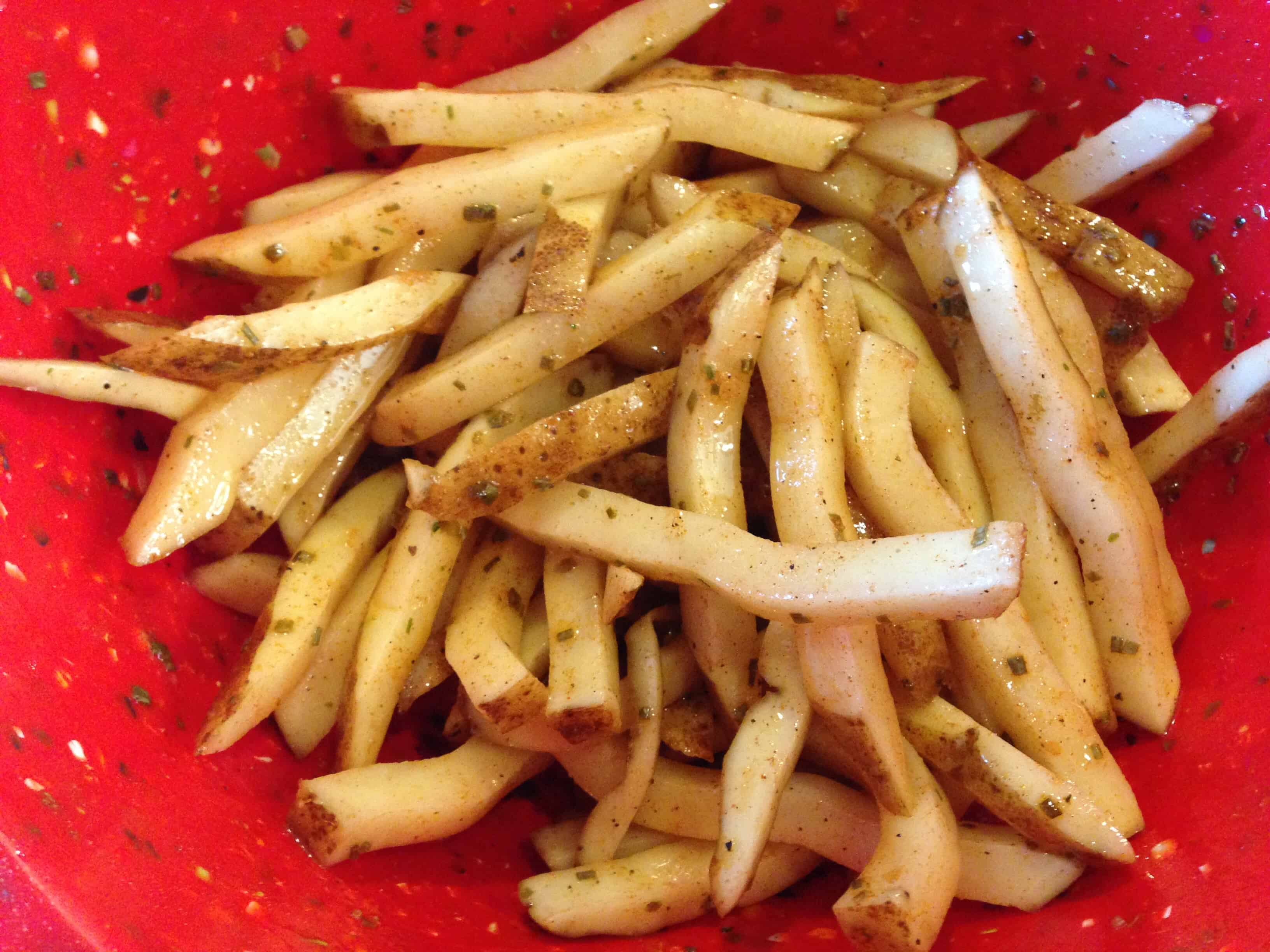 Tossing the fries with oil and seasonings before they go in the air fryer