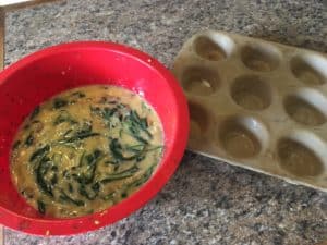 Spinach, mushroom and egg cups going into muffin pan