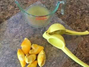 Juiced lemons with juicer and measuring cup