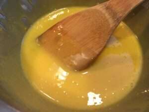 Stirring the lemon curd with a wooden spoon in double boiler