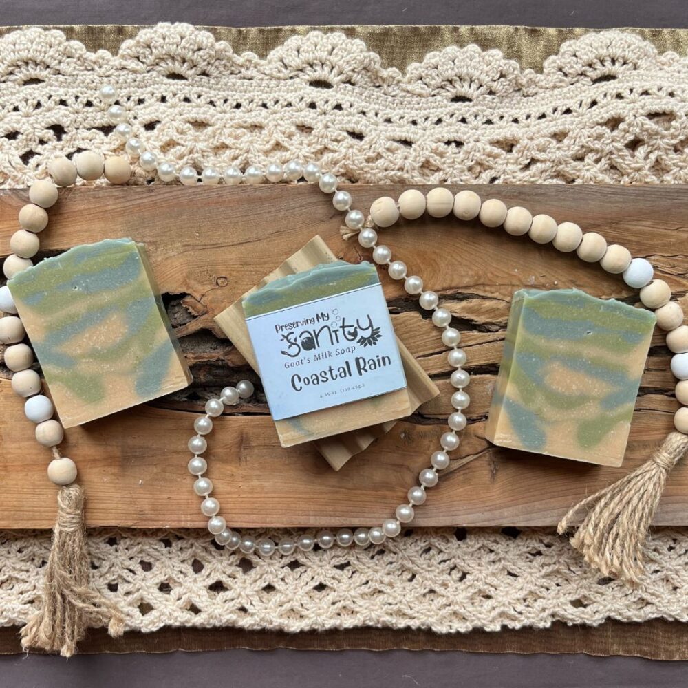 Pretty interior flatlay of coastal rain soap on a backdrop of crochet, lace, and wooden beads