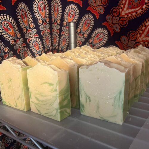 Interior photo featuring bars of handmade coconut lime verbena soap in rows on the curing rack