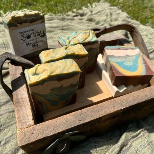 Exterior collage photo of mountain sky soap in a wooden box on a blanket in the sunshine