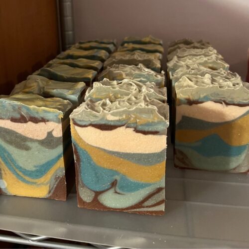 Interior photo of bars of mountain sky soap sitting upright on the curing rack