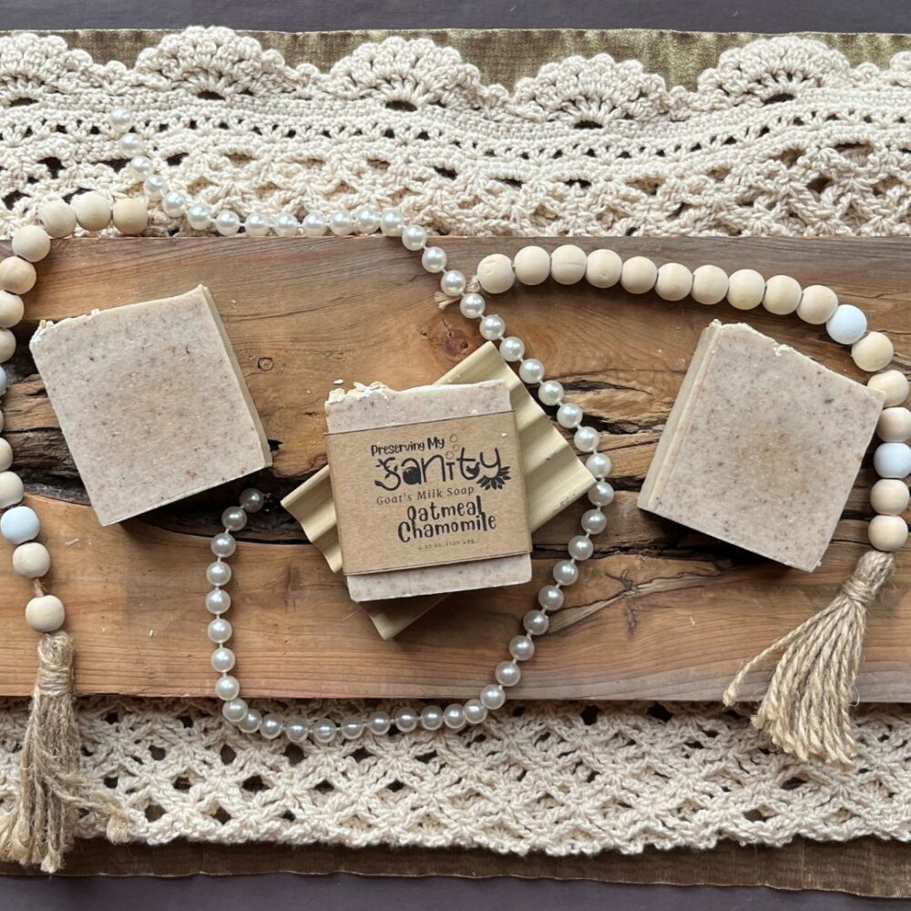 Pretty interior flatlay of oatmeal chamomile soap with a background of rustic wood, crochet, wooden beads, and pearls