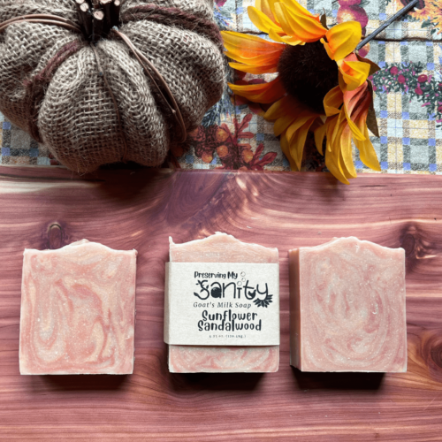 Three bars of sunflower sandalwood soap with a fall flatlay of pumpkin and sunflower.