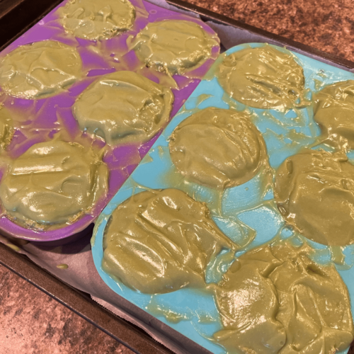 Process photo showing wet soap batter on luffa slices in a round silicon mold