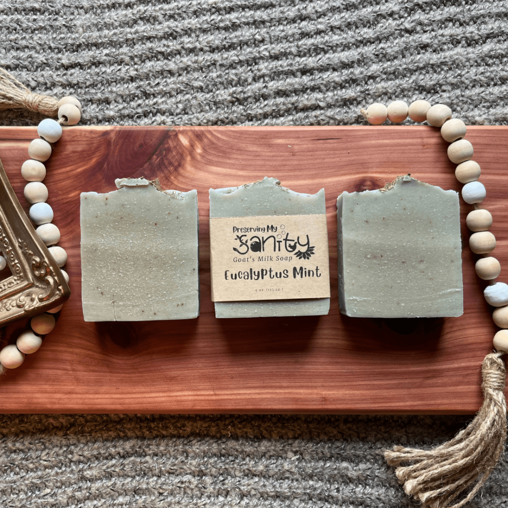 Flatlay photo showcasing three bars of Eucalyptus Mint infused and essential oil soap on a cedar board