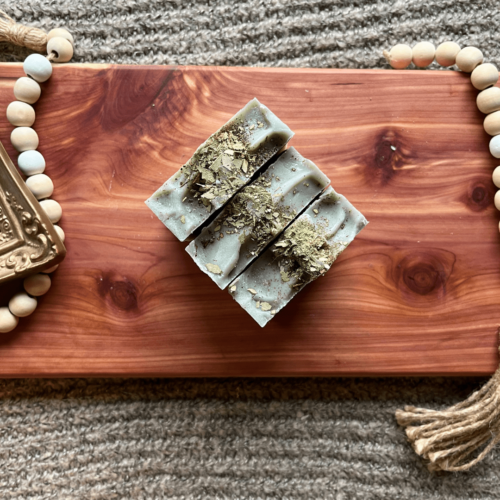 Top view of three bars of Eucalyptus Mint essential oil and infused soap on a cedar bath board