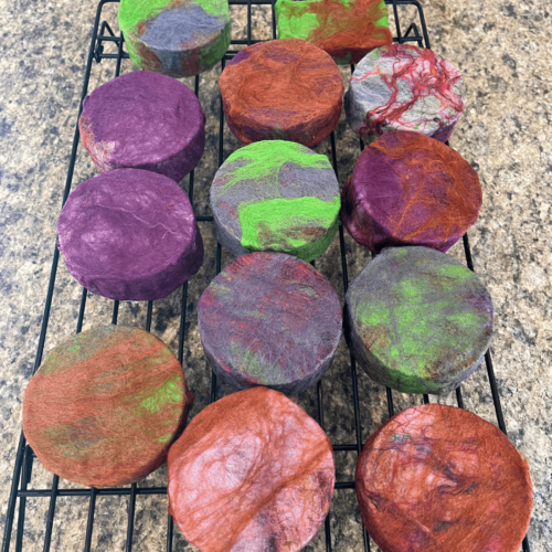 Process photo of twelve bars of felted Nag Champa soap drying on a cooling rack