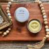 Handmade lotion bar made in a bee mold in a flatlay photo on a cedar board