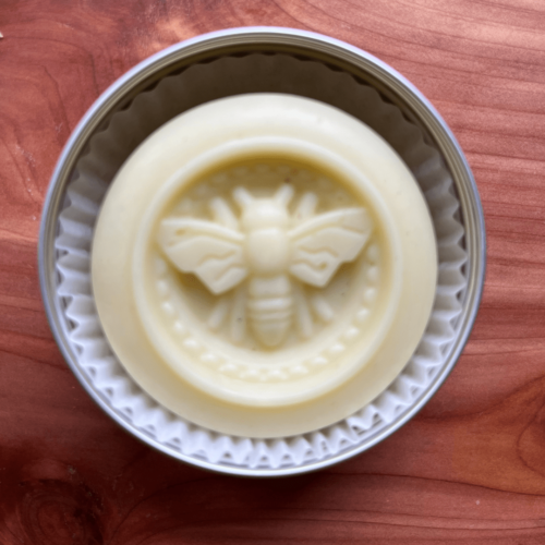 Closeup view of handmade lotion bar made in a bee mold with local Minnesota beeswax and herb-infused olive oil