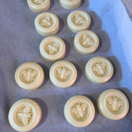 Flatlay process photo showing a dozen infused oil and beeswax lotion bars after taking them out of mold