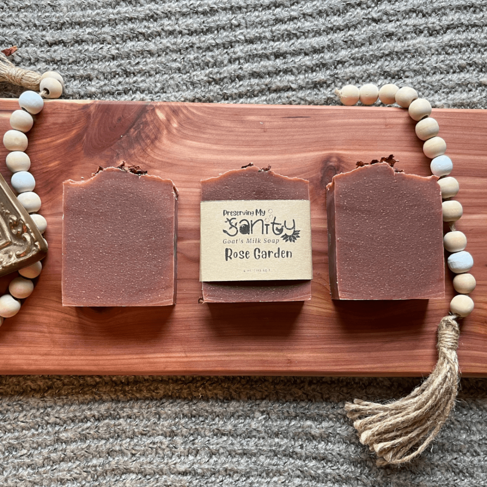 Flatlay photo of three bars of Rose Garden essential oil soap on a cedar bath board