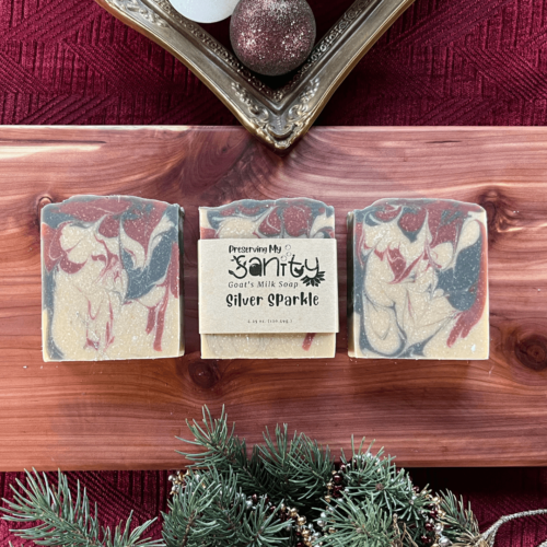 Three bars of Silver Sparkle soap on a cedar board with a holiday themed flatlay. Goat's milk handmade in Minnesota.