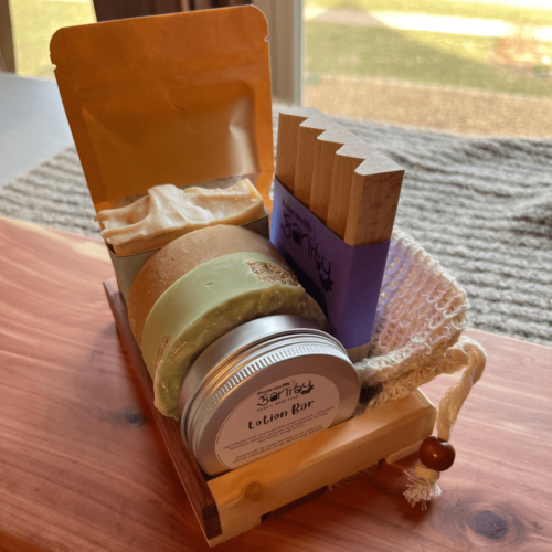 Alternate side view of the spa day bundle that includes oatmeal chamomile bath salt, coconut lime verbena bar soap, litsea and orange shaving soap, beachy luffa soap, lotion bar, wood soap dish, sisal soap saver bag, and reclaimed wood gift tray