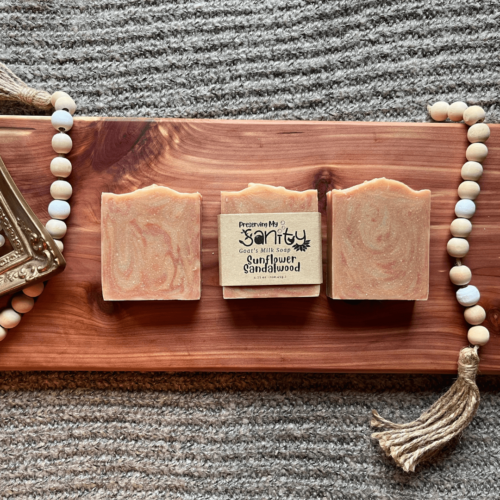 Flatlay photo showcasing three bars of sunflower sandalwood goat's milk soap