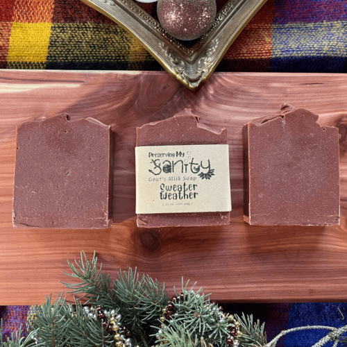 Three bars of Sweater Weather soap on a pretty plaid sweater with holiday themed flatlay. This soap has tussah silk dissolved in the batter and gets it deep rich red color from Moroccan clay.