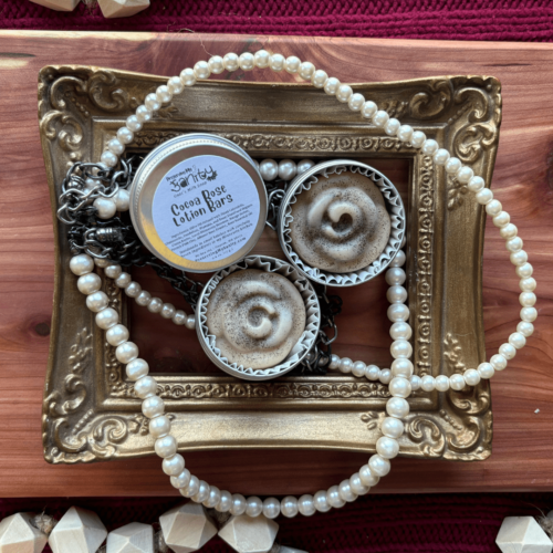 Flatlay of rose lotion bars sitting in a pretty gold frame tray with pearls