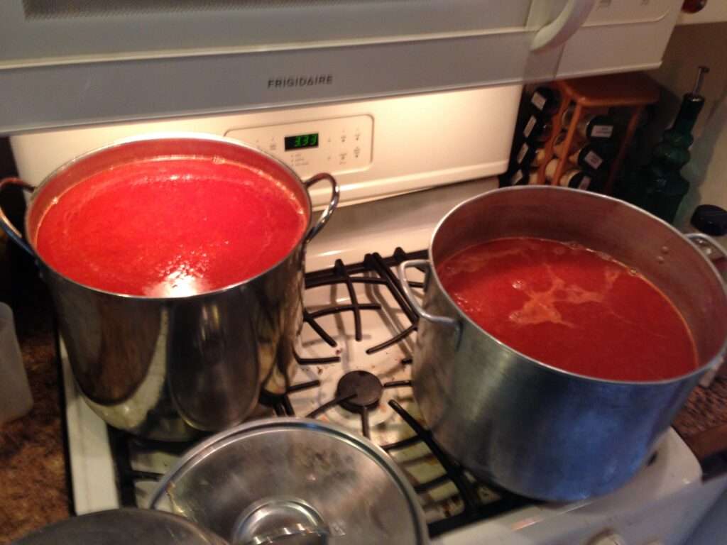 Overhead photo of two large pots of spaghetti sauce on a stove