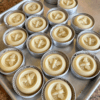 Flatlay of a process photo showing several citronella and herb lotion bars on a baking sheet