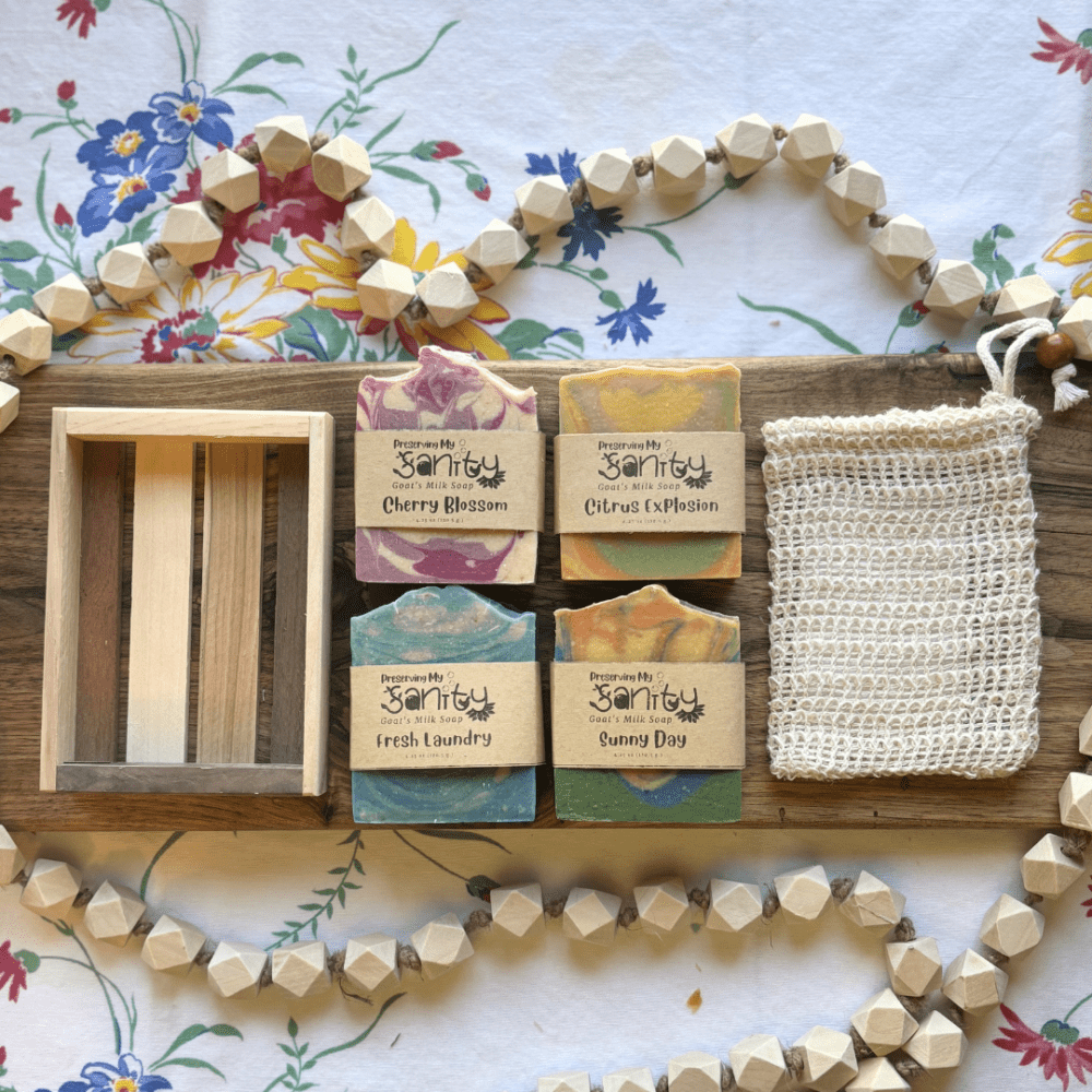 Flatlay photo of Spring Soap Bundle featuring four full-size bars, a soap saver bag, and a reclaimed wood tray