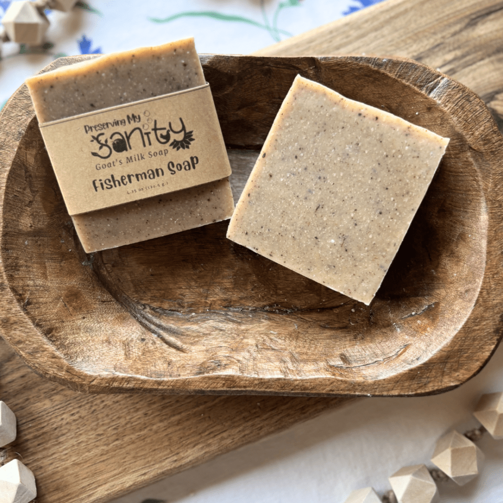 Two bars of fisherman's soap made with lemon and anise essential oils sitting in a decorative wooden bowl