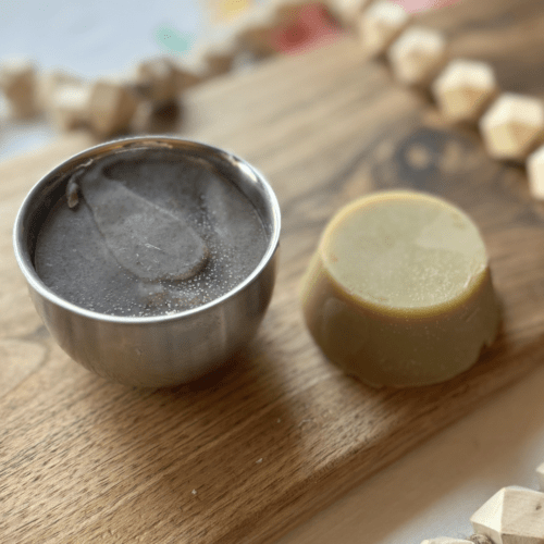 Closeup view of a stainless steel shaving bowl, pictured with a small puck of shaving soap