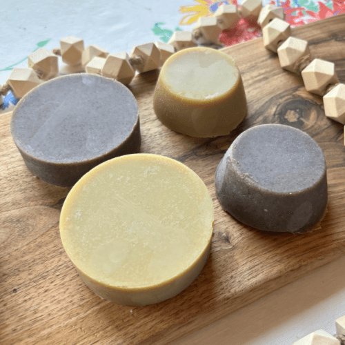 Alternate angled overhead view of four bars of shaving soap - two kinds available in two sizes