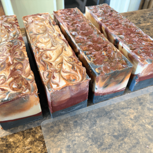 Process photo showing four loaves of bonfire swirl soap prior to cutting into bars