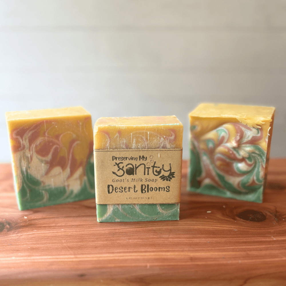 Photo of three bars of desert blooms goat milk soap displayed to show design, top, and label