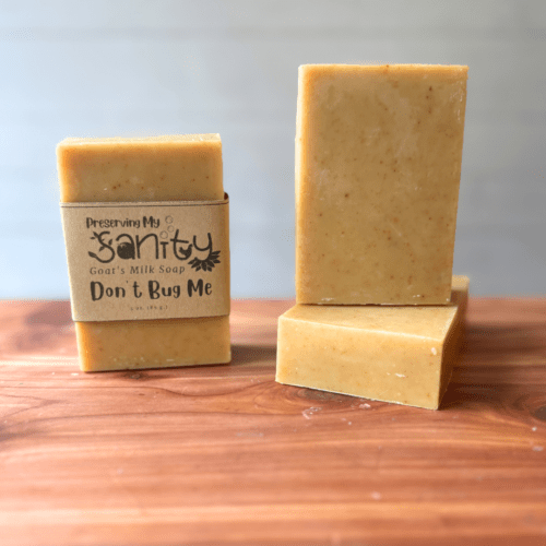 Photo of three bars of don't bug me goat milk soap displayed to show design, top, and label