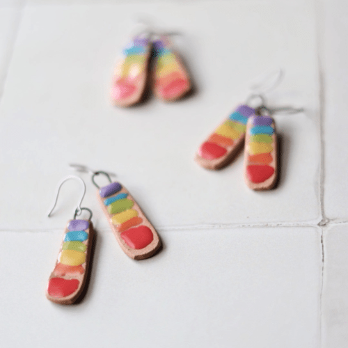 Flatlay photo of handmade ceramic chakra bar rainbow earrings