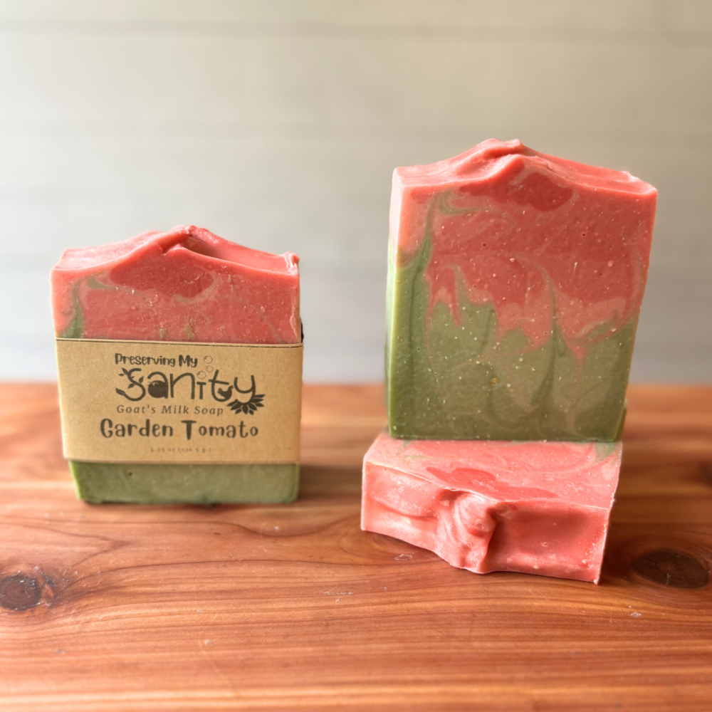 Photo of three bars of garden tomato goat milk soap displayed to show design, top, and label