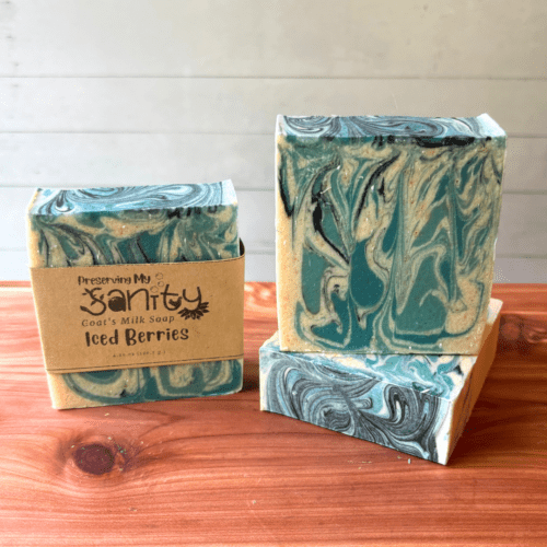 Photo of three bars of iced berries goat milk soap displayed to show design, top, and label