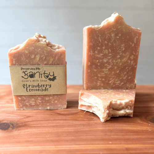 Photo of three bars of strawberry lemonade goat milk soap displayed to show design, top, and label