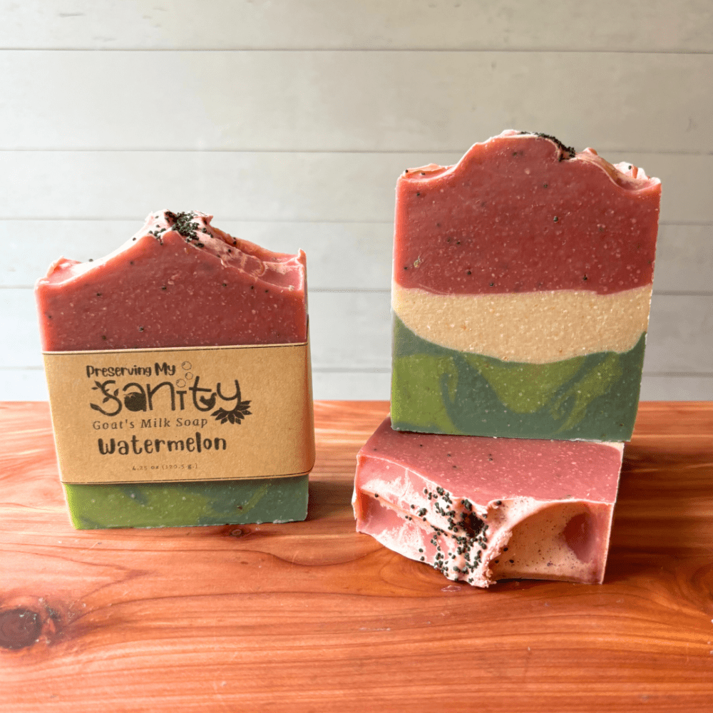 Photo of three bars of watermelon goat milk soap displayed to show design, top, and label