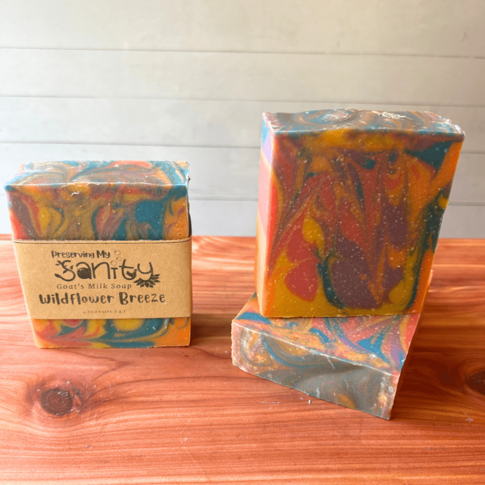 Photo of three bars of wildflower breeze goat milk soap displayed to show design, top, and label