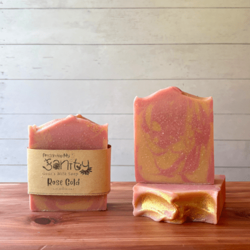 Front view photo sof three bars of Rose Gold goat milk soap, one bar with a label and the other two displayed to show different sides of the soap bars. This soap is handcrafted in small batches in Minnesota with local goat milk.