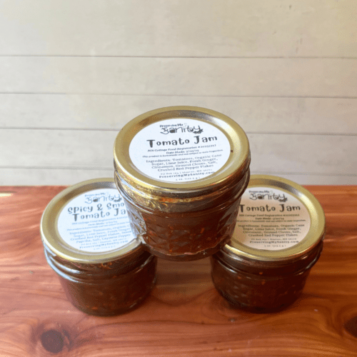 Alternate angle view showing part of top and part of side of three jars of tomato jam made with my homegrown tomatoes in my Minnesota garden.