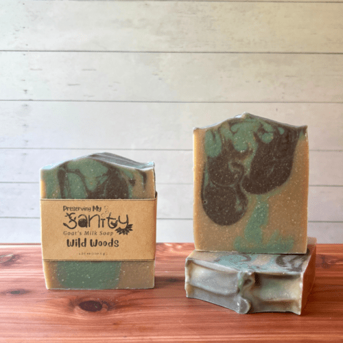 Display photo showcasing three bars of Wild Woods goat milk soap, handcrafted in small batches in Minnesota. These bars were made with a drop swirl of light aqua blue and medium brown in a naturally colored soap batter base.