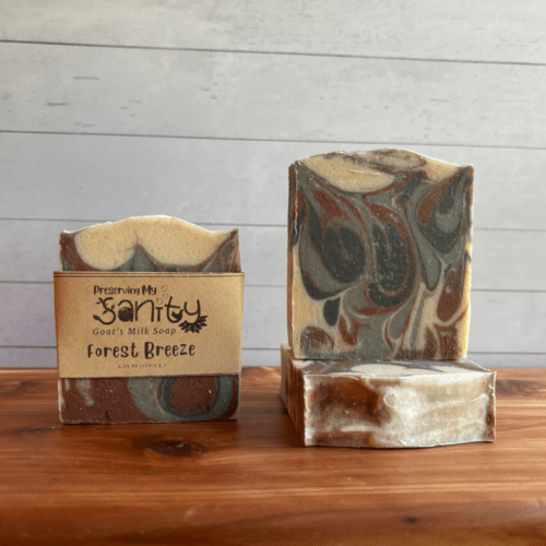 Photo of three bars of Forest Breeze goat milk soap arranged to show different angles and parts of handcrafted soap bars