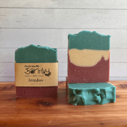 Photo of three bars of Freedom goat milk soap arranged to show different angles and parts of handcrafted soap bars