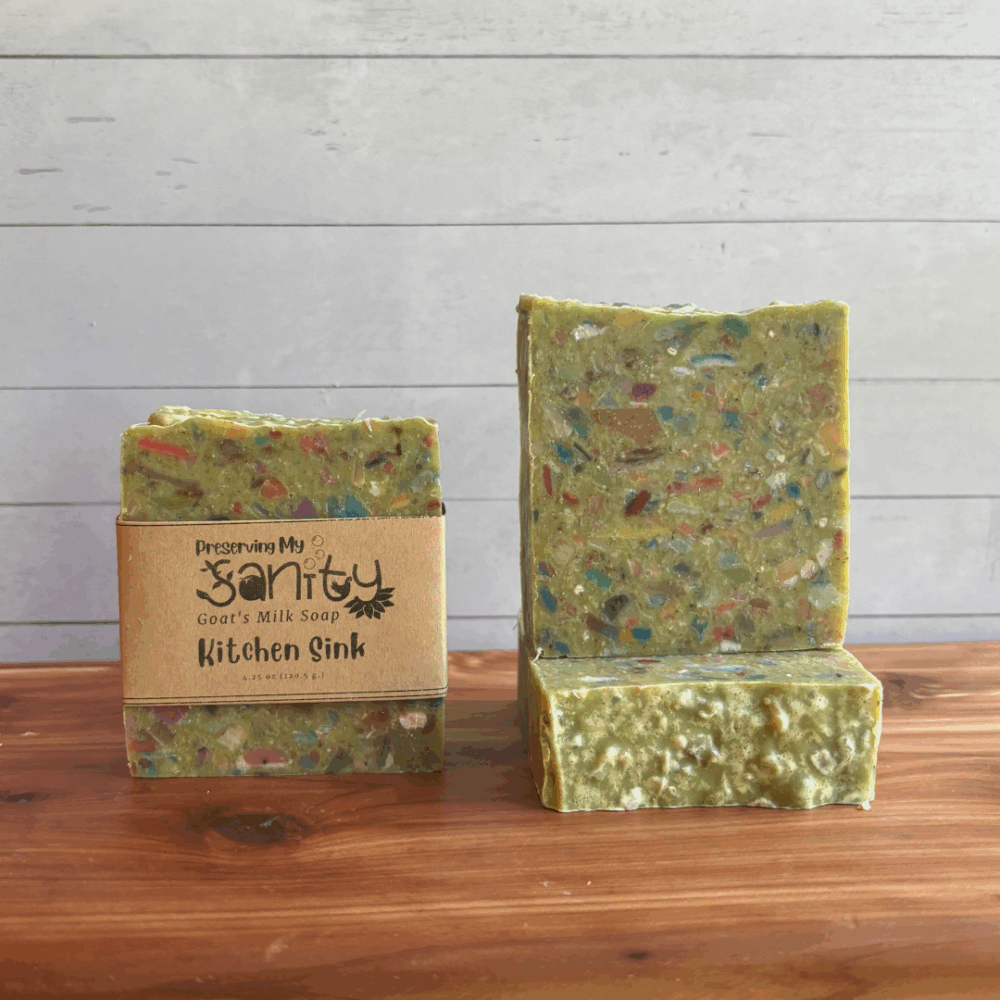 Three bars of Kitchen Sink confetti soap. The soap is a light green color with rainbow confetti bits in it, and it also has pumice powder in it for exfoliation. The scent is a greenhouse floral blend that is fresh and clean.