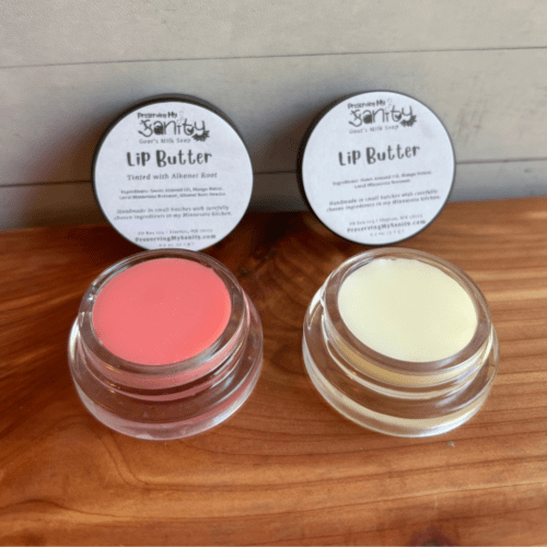 Two small glass jars of lip butter, one untinted and one light pink tinted with alkanet root. Made with nourishing ingredients and local Minnesota beeswax