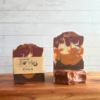 Front view of three bars of Cowboy goat milk soap showing the label, top, and full front of bar