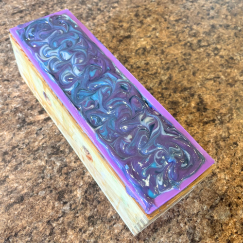 Process photo of a freshly poured loaf of Frozen Lake goat milk soap with a pretty swirled top