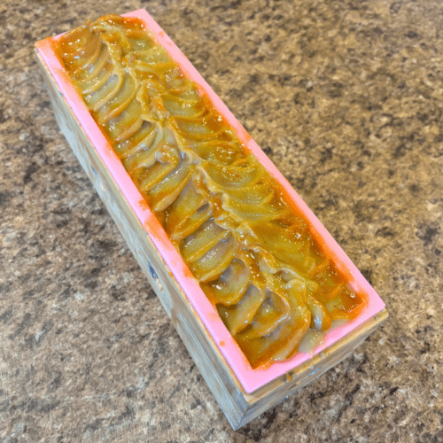 Process photo showing a freshly poured loaf of Lemongrass Patchouli goat milk soap