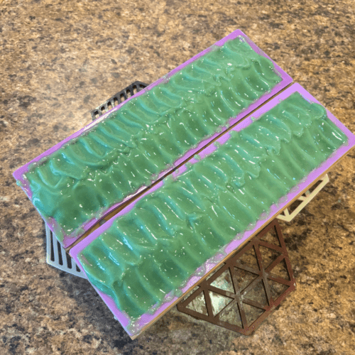 Process photo showcasing two loaves of freshly poured Mountain Spring goat milk soap with pretty textured green tops