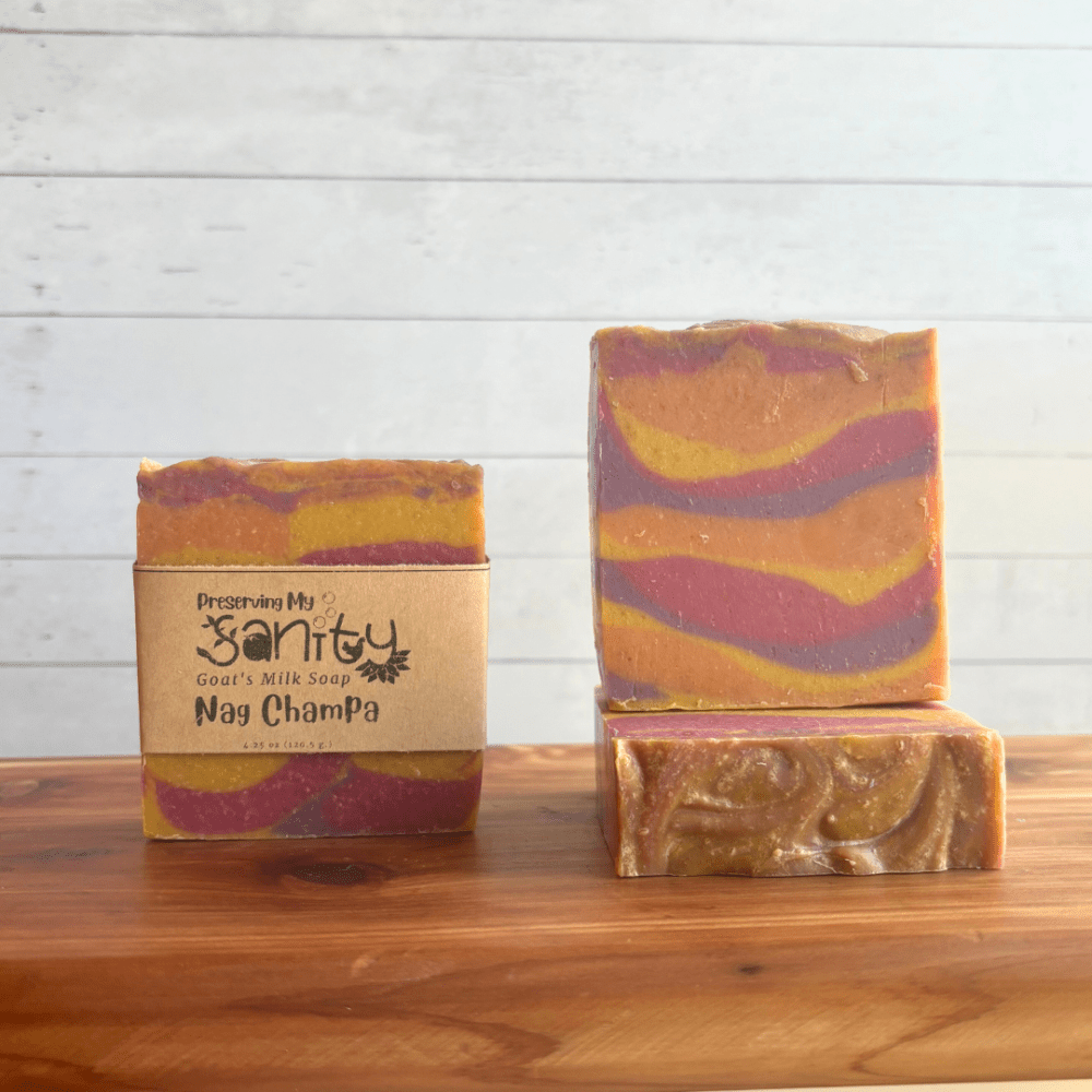 Front view display photo showcasing three bars of Nag Champa goat milk soap with colorful swirls of pink, purple, orange, and yellow